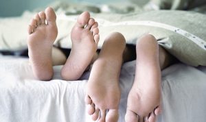 Perilaku-seksual (kaki dua pasangan di kasur)